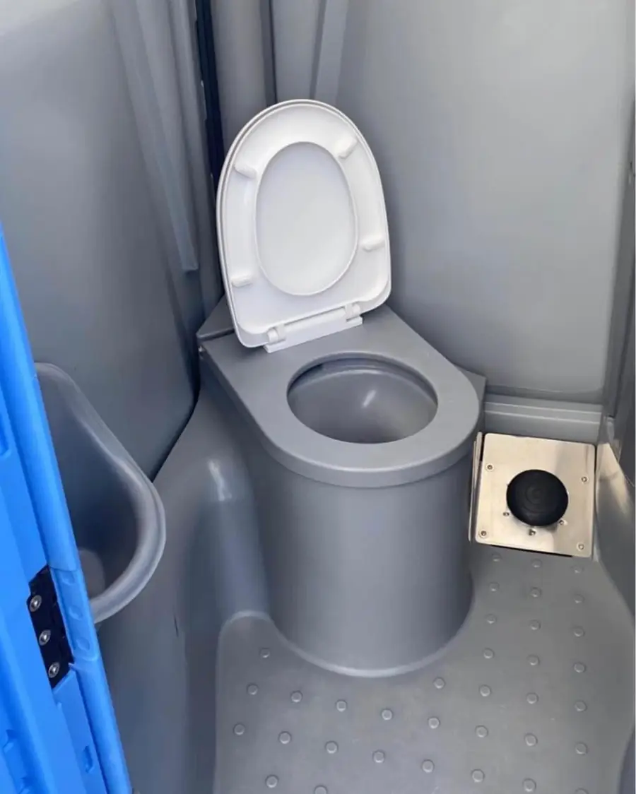 Deluxe portable toilet interior with a flushing bowl and lid
