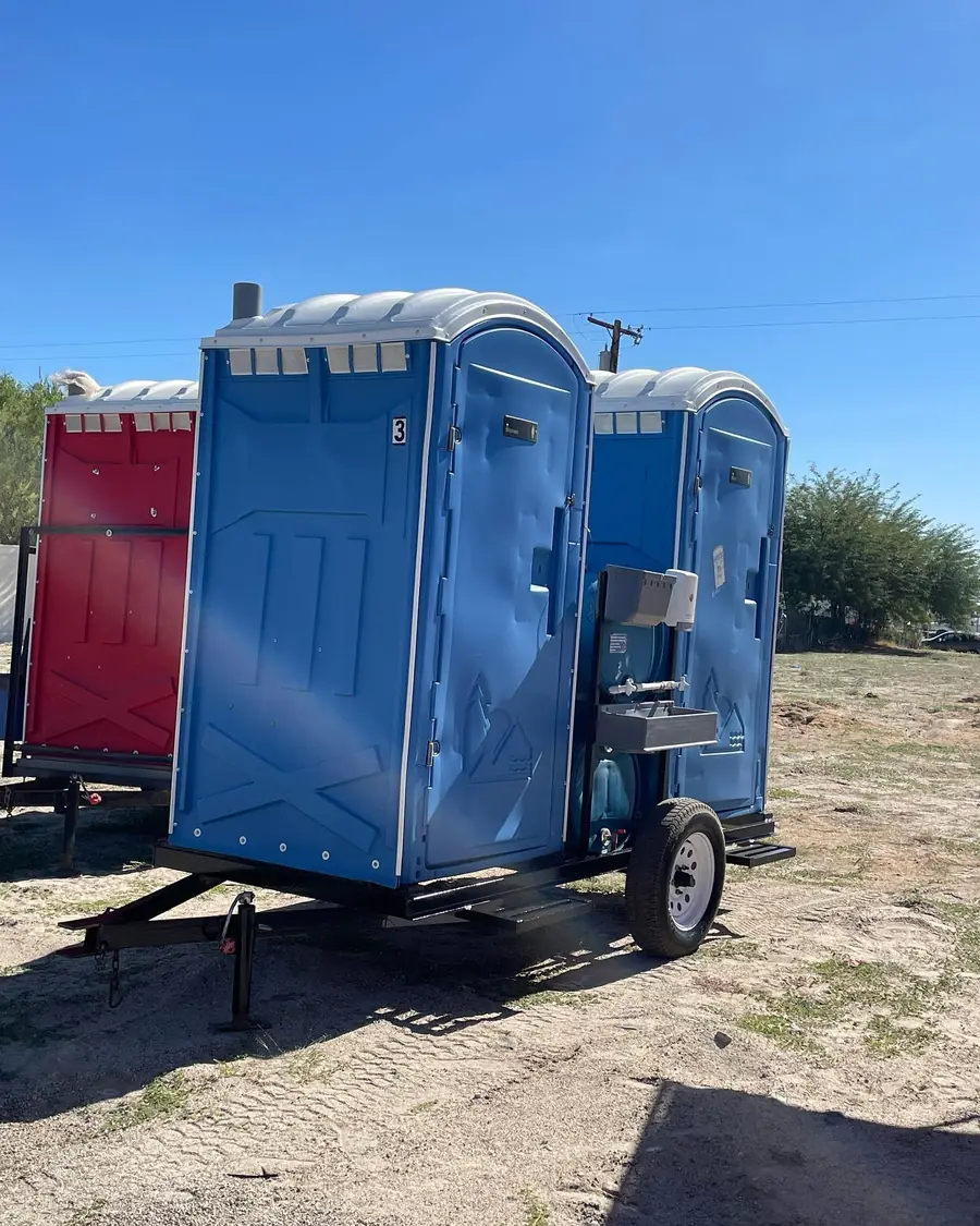 Porta potties on a towable trailer at an open jobsite